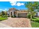 Charming home exterior with a brick driveway, a well-maintained lawn, and a stone entryway at 6909 Crestpoint Dr, Apollo Beach, FL 33572