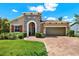 Beautiful single-Gathering home featuring a stone facade, brick driveway, and manicured lawn at 6909 Crestpoint Dr, Apollo Beach, FL 33572
