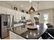 Modern kitchen with stainless steel appliances, dark granite countertops, and a large island at 6909 Crestpoint Dr, Apollo Beach, FL 33572