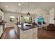 Open kitchen with granite island, stainless appliances, pendant lighting, and hardwood floors flowing into the living area at 6909 Crestpoint Dr, Apollo Beach, FL 33572