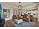 Open-concept living room with a modern chandelier, wood floors, and seamless flow to the kitchen at 6909 Crestpoint Dr, Apollo Beach, FL 33572
