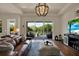 Bright living room with a leather sofa, modern lighting, and a view of the backyard pool and landscaping at 6909 Crestpoint Dr, Apollo Beach, FL 33572