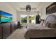 Comfortable Primary bedroom with a large window overlooking the outdoors, dresser, and large TV at 6909 Crestpoint Dr, Apollo Beach, FL 33572