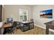 Well-lit office with a patterned rug, a large window with blinds, and a modern wooden desk at 6909 Crestpoint Dr, Apollo Beach, FL 33572