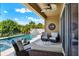 This covered patio offers comfortable seating and beautiful views of the backyard pool and waterfall at 6909 Crestpoint Dr, Apollo Beach, FL 33572
