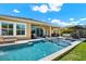 Relax in this backyard pool featuring a sun shelf, and outdoor dining and living areas at 6909 Crestpoint Dr, Apollo Beach, FL 33572