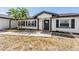 Close-up of the home's front entrance featuring stone flower bed borders and lush palm trees at 7607 22Nd W Ave, Bradenton, FL 34209