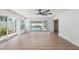 Bright living room with wood floors, ceiling fan, and a view of the screened in pool at 7607 22Nd W Ave, Bradenton, FL 34209