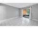 Bedroom featuring tiled flooring, light gray walls, and sliding glass door leading to the patio at 8039 Garden Dr # 105, Seminole, FL 33777