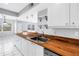 Bright kitchen features white cabinets, stainless steel sink, wooden countertops and a Samsung dishwasher at 8039 Garden Dr # 105, Seminole, FL 33777