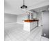 Open kitchen and living room with white tile flooring, stainless steel appliances, and wood countertops at 8039 Garden Dr # 105, Seminole, FL 33777