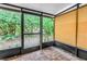 Screened patio features wood-look flooring, metal supports, and lush views of the landscaped yard at 8039 Garden Dr # 105, Seminole, FL 33777