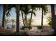 Scenic outdoor seating area with wicker chairs and tables, palm trees, and an ocean view at sunset at 805 S Gulfview Blvd # 305B, Clearwater, FL 33767