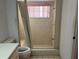 Bathroom with tiled shower, a small bench, and window with natural light at 8130 Shalom Dr, Spring Hill, FL 34606