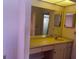 Bathroom featuring yellow vanity area and mirror, in need of upgrades at 8130 Shalom Dr, Spring Hill, FL 34606