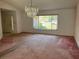 Spacious living room featuring a chandelier and a large window providing natural light at 8130 Shalom Dr, Spring Hill, FL 34606
