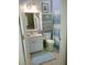Bathroom features a modern sink and vanity, decorative mirror and cabinet, and shower with blue and white curtain at 834 Tremont Greens Ln # 137, Sun City Center, FL 33573