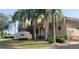 Exterior view of a golf club with lush greenery, palm trees, and a welcoming sign at 834 Tremont Greens Ln # 137, Sun City Center, FL 33573