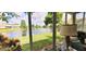 Relaxing lanai view showcasing a serene lake, lush greenery, and beautiful landscaping at 834 Tremont Greens Ln # 137, Sun City Center, FL 33573