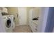 Bright laundry room with new washer and dryer, granite counters, storage, and tile flooring at 834 Tremont Greens Ln # 137, Sun City Center, FL 33573