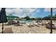 Outdoor swimming pool with lounge chairs and umbrellas on a sunny day at 834 Tremont Greens Ln # 137, Sun City Center, FL 33573
