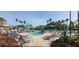 Large outdoor pool area with lounge chairs, umbrellas, and tropical palm trees at 834 Tremont Greens Ln # 137, Sun City Center, FL 33573