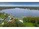 Aerial view of property featuring lakeside access, private pool, and mature tree coverage at 8701 Lake Calm Ln, Odessa, FL 33556