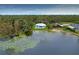 Aerial view of the estate home with lake frontage, boat dock and private in ground pool at 8701 Lake Calm Ln, Odessa, FL 33556