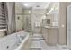 Relaxing bathroom featuring a soaking tub, glass shower, and dual sinks, perfect for unwinding at 8701 Lake Calm Ln, Odessa, FL 33556