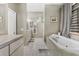 Elegant bathroom featuring a soaking tub, dual vanities, and a serene color palette at 8701 Lake Calm Ln, Odessa, FL 33556