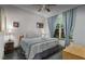 Comfortable bedroom with a queen-sized bed, matching bedside tables and lamps, and window with blue curtains at 8701 Lake Calm Ln, Odessa, FL 33556
