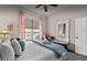 Bright bedroom with ceiling fan, view of the lake, and a decorative mirror over a bench at 8701 Lake Calm Ln, Odessa, FL 33556