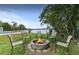 Backyard brick fire pit with chairs with waterfront views of the lake in background at 8701 Lake Calm Ln, Odessa, FL 33556