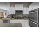 Well-equipped kitchen with stainless steel appliances, tile backsplash, and plenty of cabinet space at 8701 Lake Calm Ln, Odessa, FL 33556