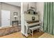 Cozy living area featuring a vintage white piano and hardwood floors, creating a unique space at 8701 Lake Calm Ln, Odessa, FL 33556