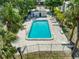 An aerial view captures a fenced pool area with lounge chairs and surrounding palm trees at 9130 Tudor Dr # M105, Tampa, FL 33615