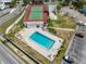 Aerial view of a pool with lounge chairs and a tennis court nearby at 9130 Tudor Dr # M105, Tampa, FL 33615
