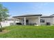 Well-maintained backyard with green grass, a covered patio, and a privacy fence, offering a serene outdoor space at 9647 Summers Cay Cir, Thonotosassa, FL 33592