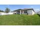 Lush backyard featuring green grass, a covered patio, a privacy fence, and mature tree, ideal for outdoor enjoyment at 9647 Summers Cay Cir, Thonotosassa, FL 33592