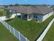 Spacious backyard with green grass, white fence, covered patio with furniture, ideal for outdoor relaxation and entertaining at 9647 Summers Cay Cir, Thonotosassa, FL 33592