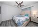 Cozy bedroom featuring a ceiling fan, modern wood flooring, and a comfortable bed with stylish bedding at 9647 Summers Cay Cir, Thonotosassa, FL 33592
