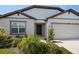 Inviting front exterior features a lush garden, a well-maintained lawn, and a welcoming entrance to the home at 9647 Summers Cay Cir, Thonotosassa, FL 33592