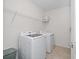 Bright laundry room with a modern washer and dryer, complemented by convenient overhead storage and neutral tile flooring at 9647 Summers Cay Cir, Thonotosassa, FL 33592