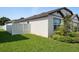 The side yard shows healthy green grass, a white fence, lush foliage, and the home's exterior at 9647 Summers Cay Cir, Thonotosassa, FL 33592
