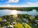 Stunning aerial view showcases waterfront property with manicured lawns, fountain, and beautiful lake views under a sunny sky at 18258 Wayne Rd, Odessa, FL 33556