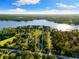 Expansive aerial view reveals the property's generous land and lake access, surrounded by lush greenery and serene waters at 18258 Wayne Rd, Odessa, FL 33556
