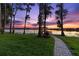 Picturesque backyard with a charming stone path leading to a private dock on the serene lake, perfect for relaxation at 18258 Wayne Rd, Odessa, FL 33556
