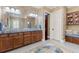Bathroom featuring double sinks, custom cabinetry, and well-lit with a large mirror at 18258 Wayne Rd, Odessa, FL 33556