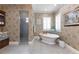 Elegant bathroom featuring a soaking tub, walk-in shower, and neutral tones at 18258 Wayne Rd, Odessa, FL 33556