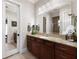 Bathroom vanity with granite counters, dark wood cabinets, and framed mirror at 18258 Wayne Rd, Odessa, FL 33556